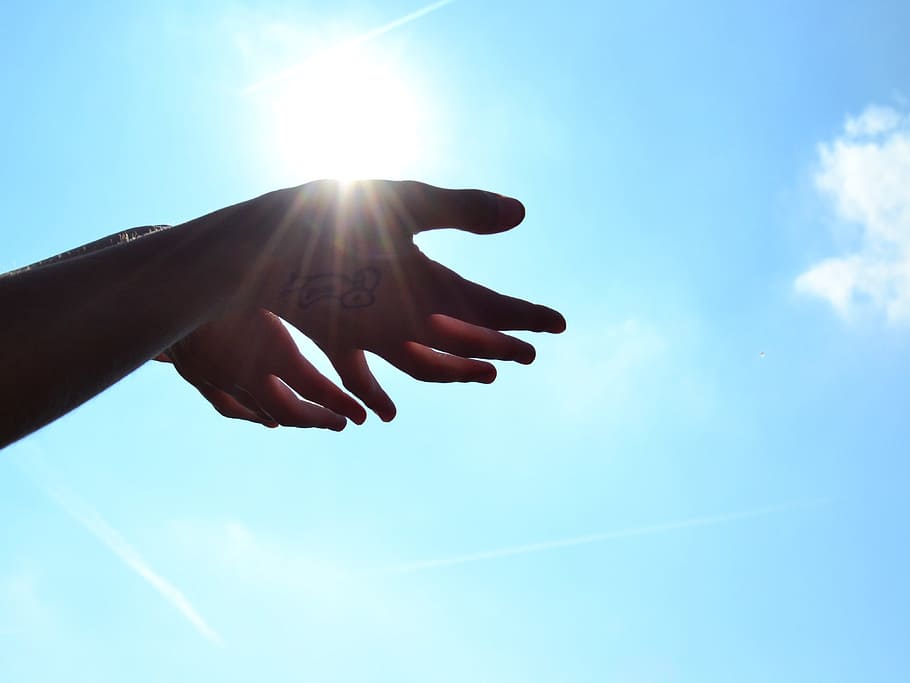 selective photo of human hand under blue and white sky at daytime HD wallpaper