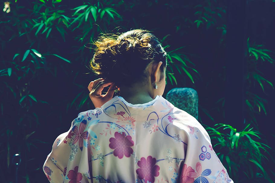 woman wearing floral top holding her ears, ancient, asia, back view