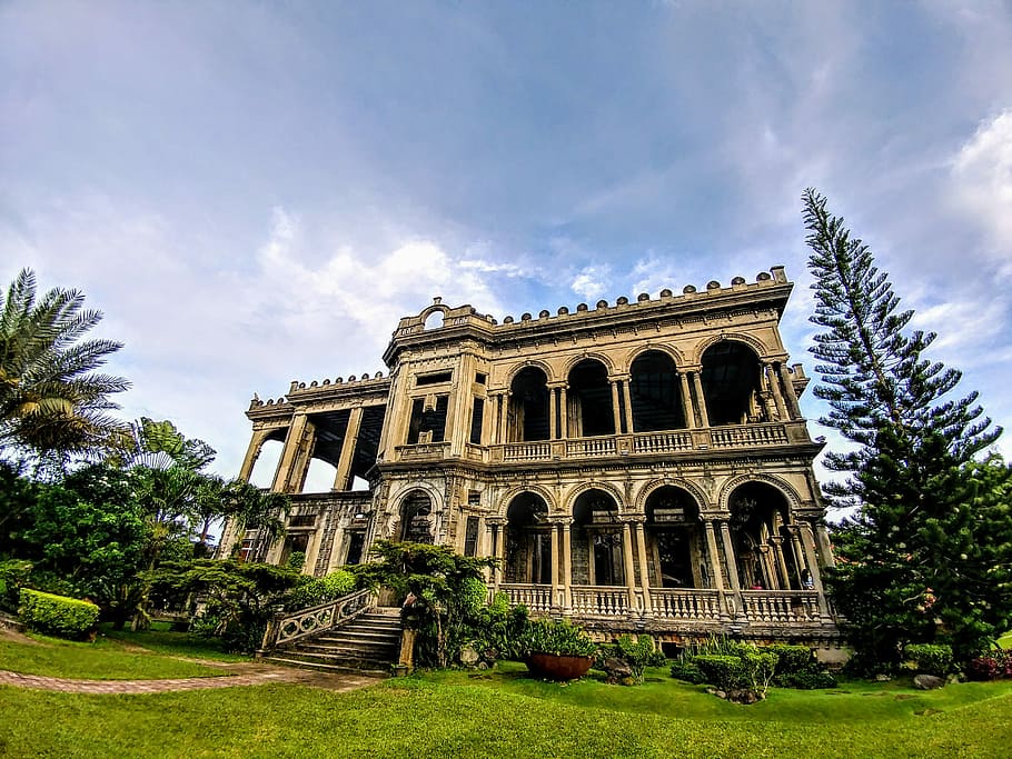 low-angle photography of brown concrete 2-storey building between trees, man's eye view of mansion near trees HD wallpaper