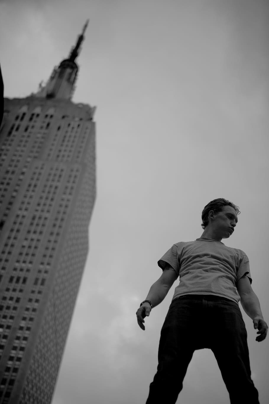 grayscale low-angle photo of man standing near building, grayscale photography of a man standing near building HD wallpaper