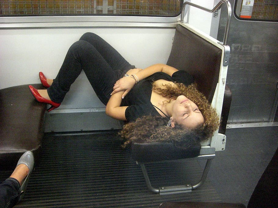 woman lying on train seat, young woman, sleeping on the subway