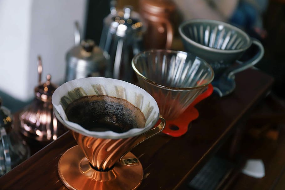 three coffee cups on surface, three filed clear glass cups, jug