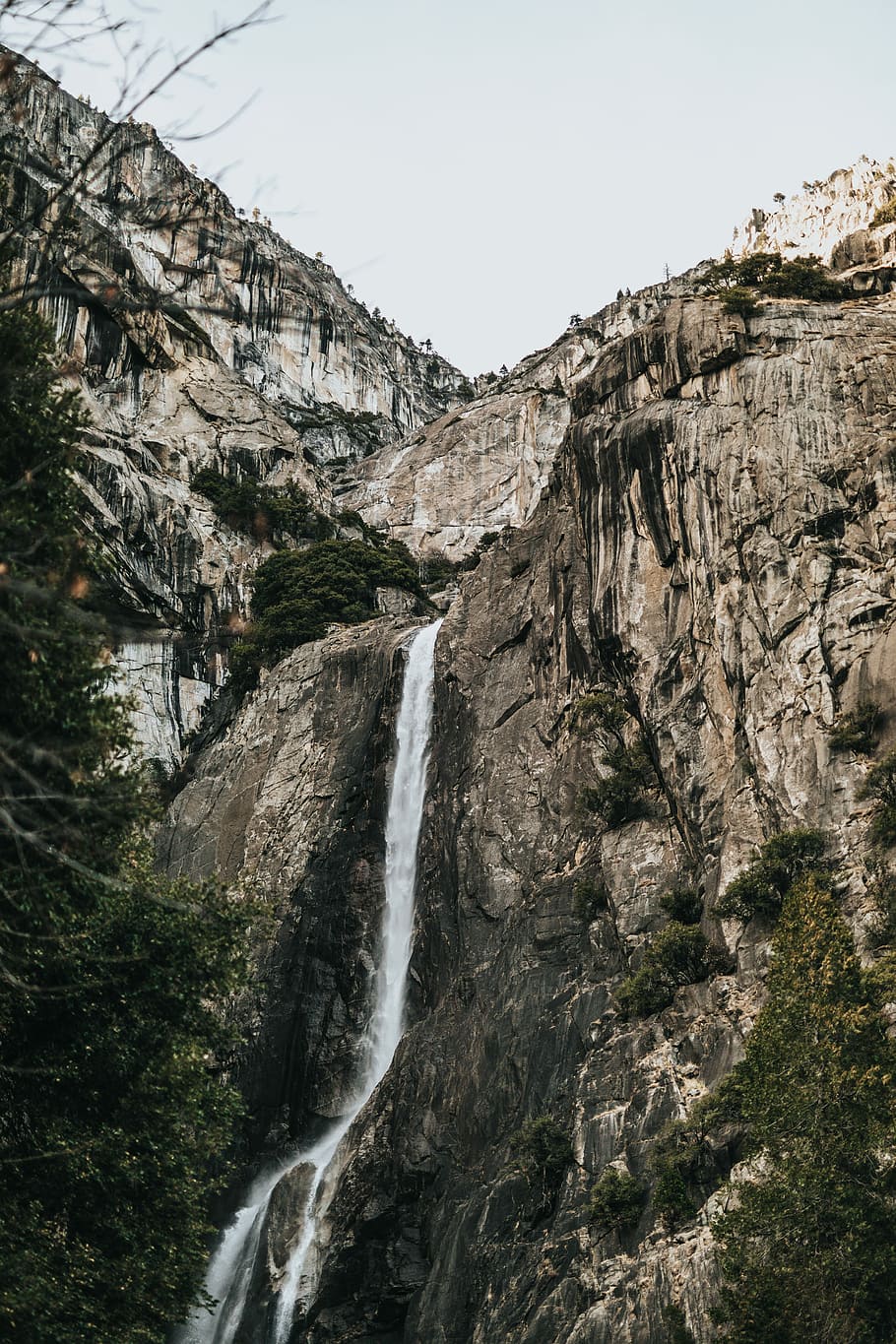 landscape photography of waterfalls surrounded by trees, gray stone water fall falling down during daytime HD wallpaper