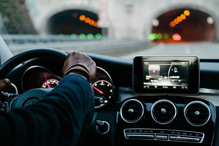 person inside vehicle holding steering wheel, person driving vehicle on road near tunnel HD wallpaper