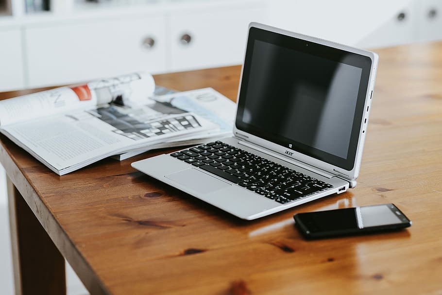 Silver laptop with various items on a table, magazines, computer HD wallpaper
