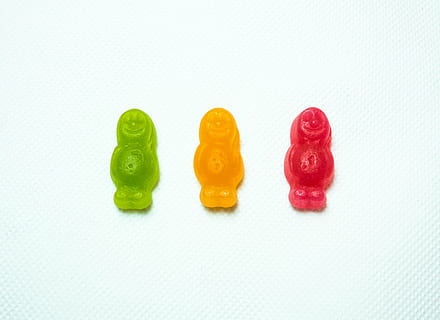 three assorted-color person figures on white surface, gummy HD wallpaper