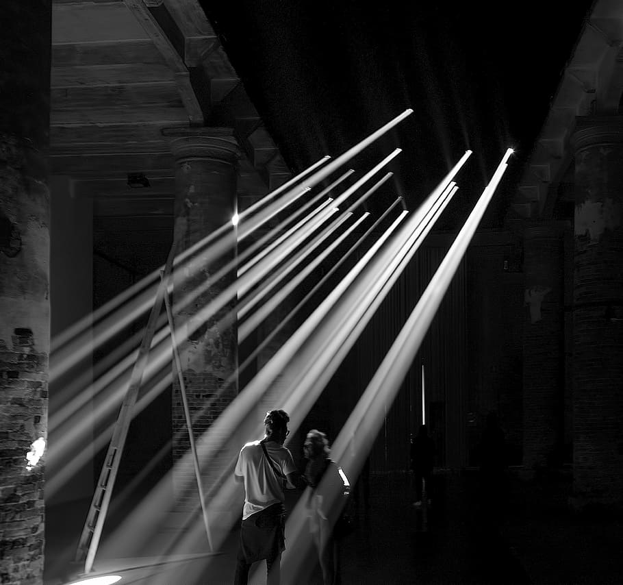 man standing near post, grayscale photography of two person standing on the ray of sun light HD wallpaper