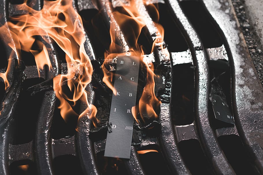black label burning on coal grill, black product tag burning on black grill HD wallpaper