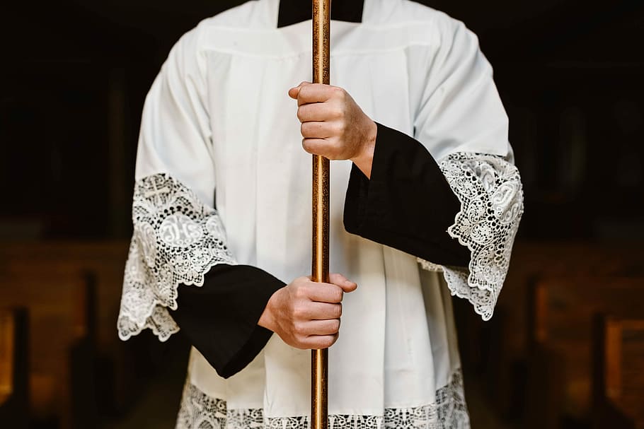 person wearing white surplice holding rod, person holding brass pole HD wallpaper