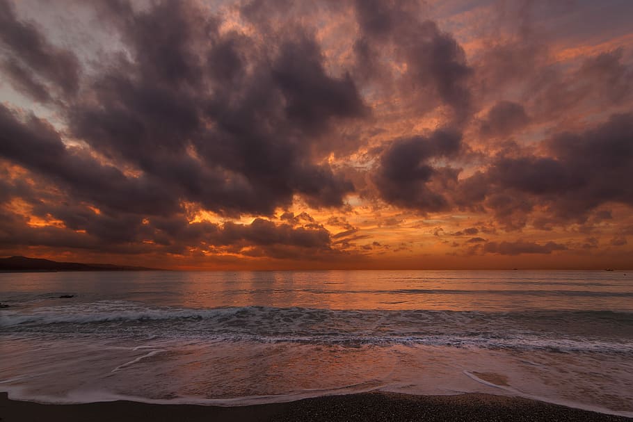 photo of beach at golden hour, shore under orange and gray sky at dusk HD wallpaper