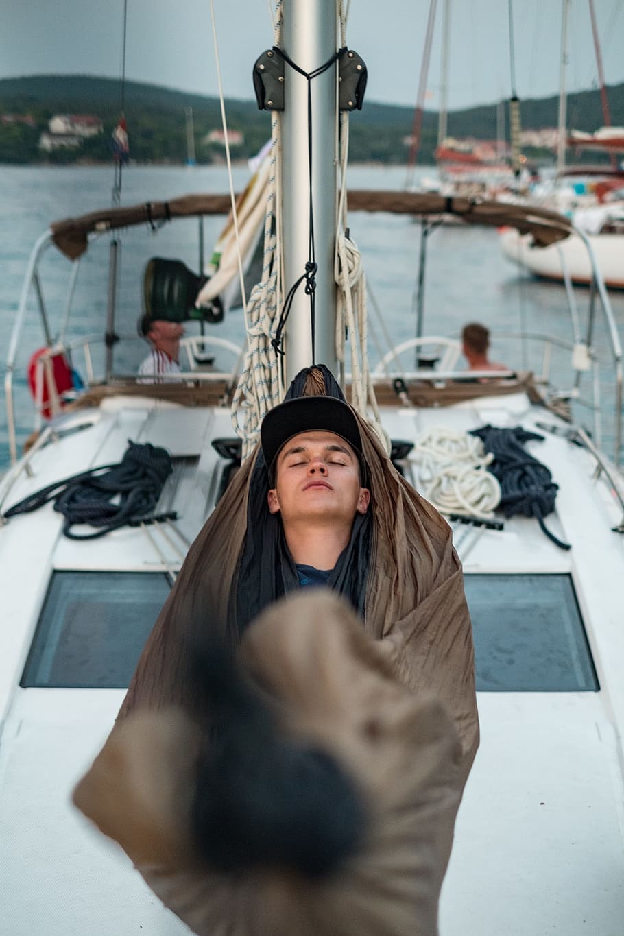 man sleeping on boat hammock, man lying on brown hammock, Sleepy