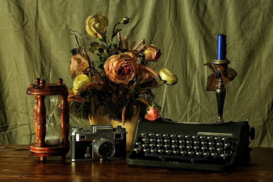 typewriter beside camera, hourglass, flower decor, and candlestick with candle on table, HD wallpaper