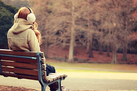 woman sitting on bench while listening music during daytime, outdoors HD wallpaper