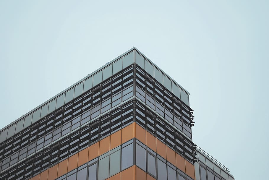 low-angled photography of concrete building under cloudy sky, gray and orange concrete building under blue sky at daytime HD wallpaper