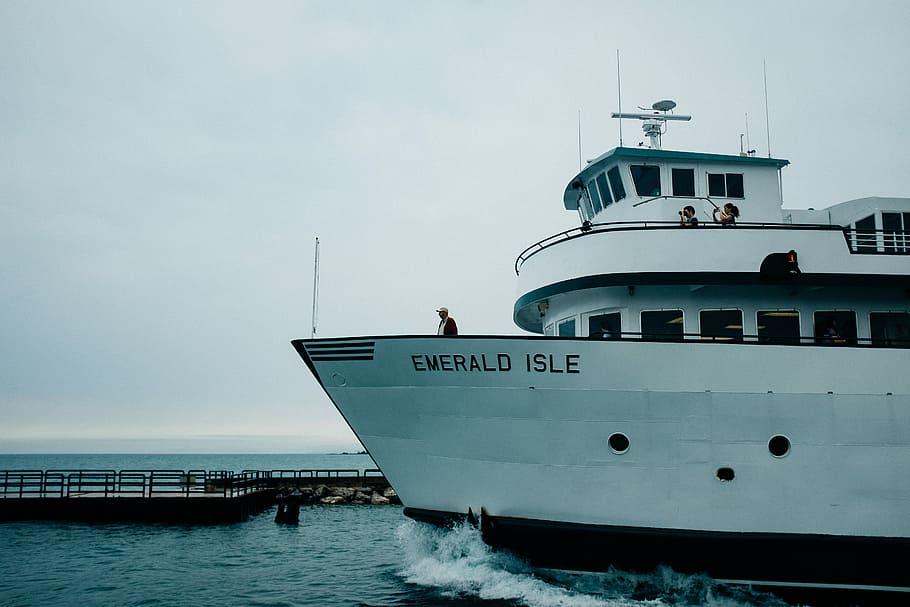 white Emerald Isle boat near dock at daytime, man standing on Emerald Isle ship HD wallpaper