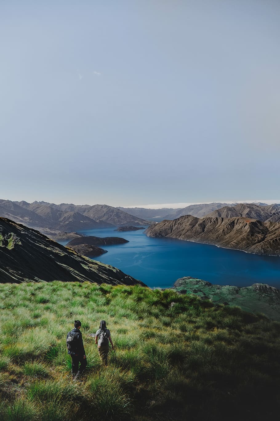 two person on green hill, woman and man walking in front of river\ HD wallpaper