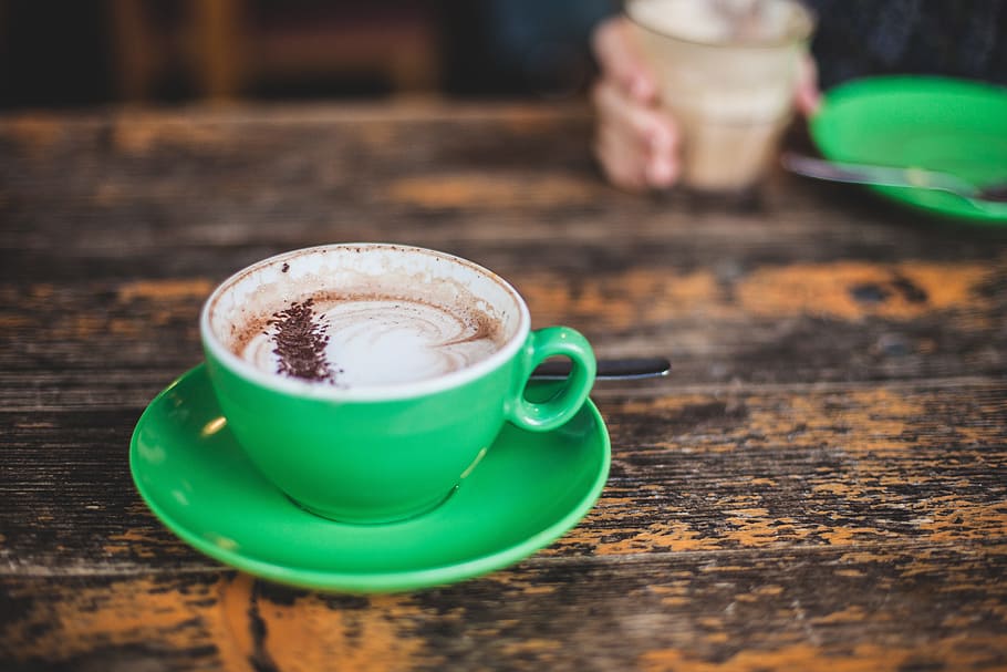 brown coffee filled green ceramic cup with saucer on top of brown table HD wallpaper