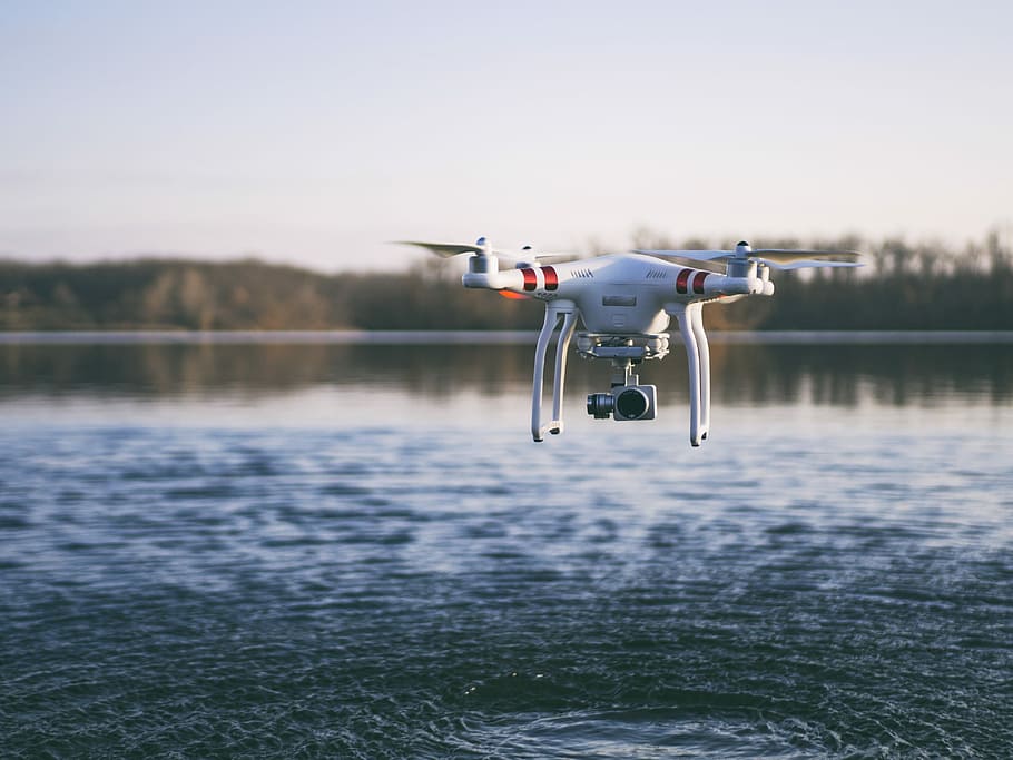 white quadcopter drone flying above body of water, white DJI quadcopter drone flying above body of water HD wallpaper