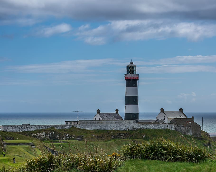 white and black lighthouse near houses during daytime, coast HD wallpaper