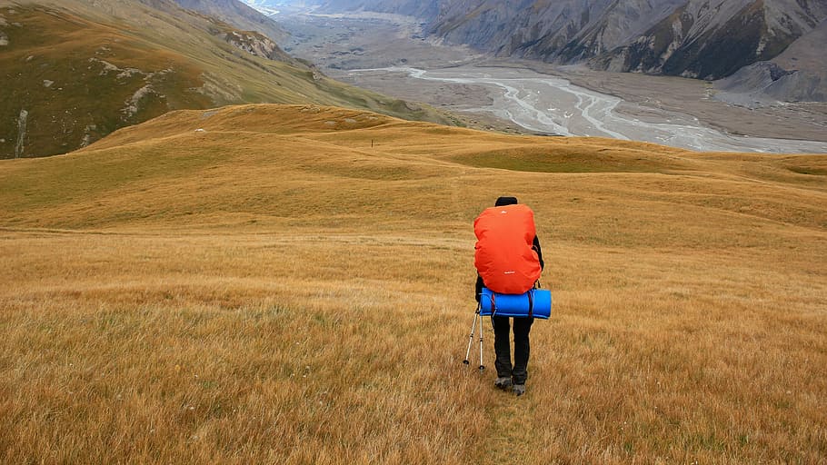 person walking on mountain, person carrying bag walking on mountain during daytime HD wallpaper