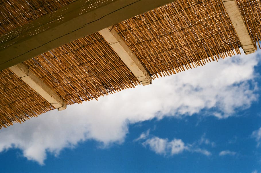 brown straw roof with brown wooden exposed beams under blue sky and white clouds at daytime, wicker roof with wooden bar frame, HD wallpaper