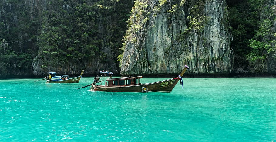 brown row boat near rocky mountain, thailand, phuket, koh phi phi