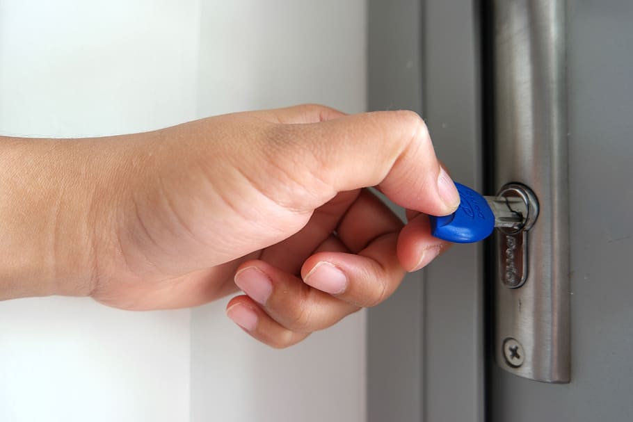 person using blue key, door, opening door, lock, security, house