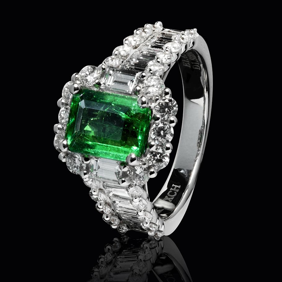 silver-colored ring with clear and green gemstones, emerald, luxury