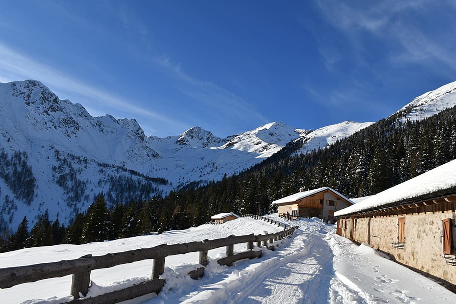 brown concrete house and snow covered mountain under blue sky at daytime HD wallpaper
