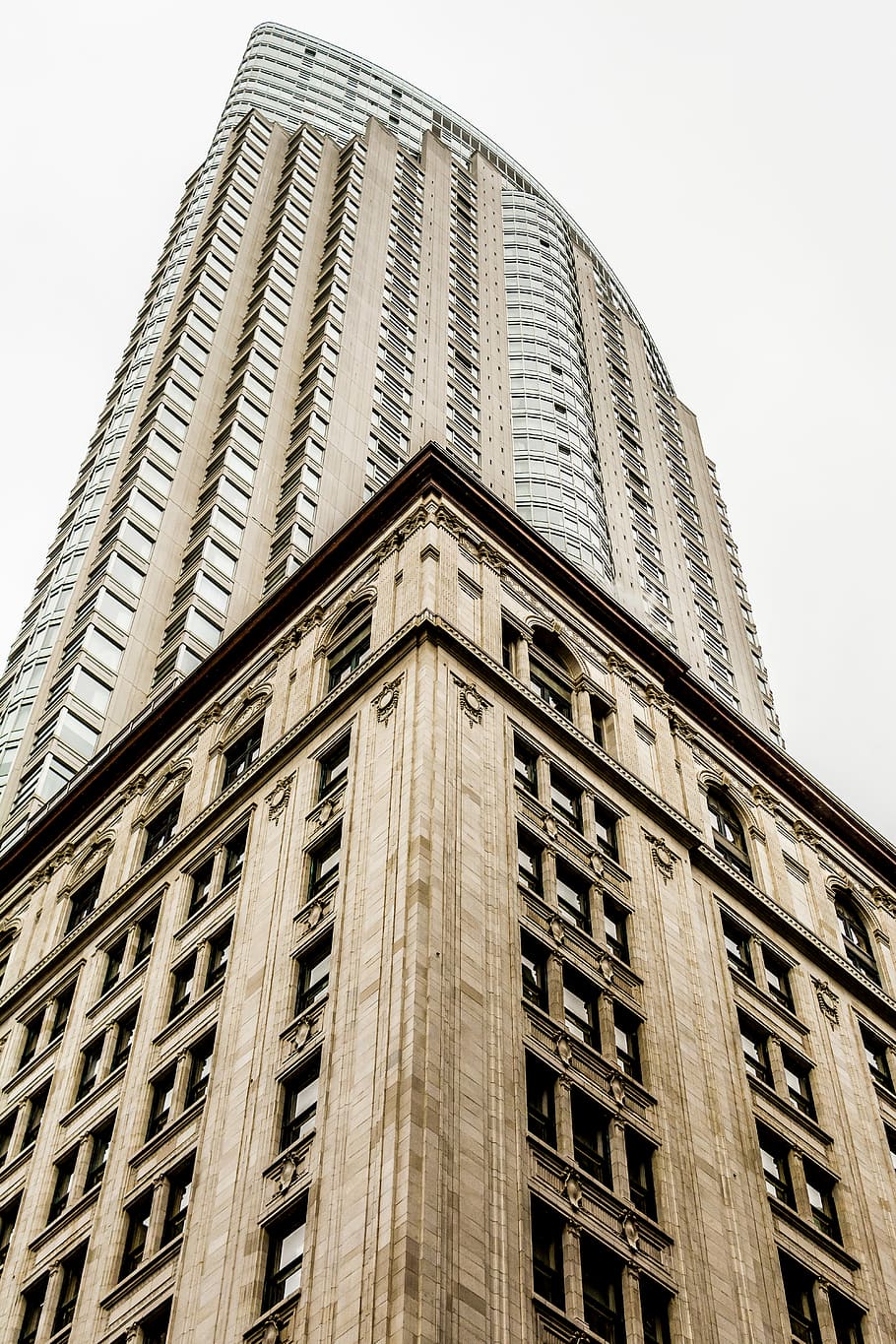 low angle photo of high rise building under gray sky, brown concrete high-rise building under cloudy skies HD wallpaper