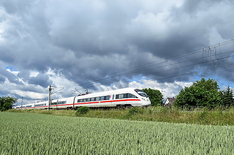 selective focus photography of white and red bullet train passing through grass field HD wallpaper