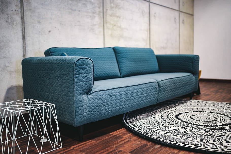 Blue sofa with pillows in a designer living room interior, home decor