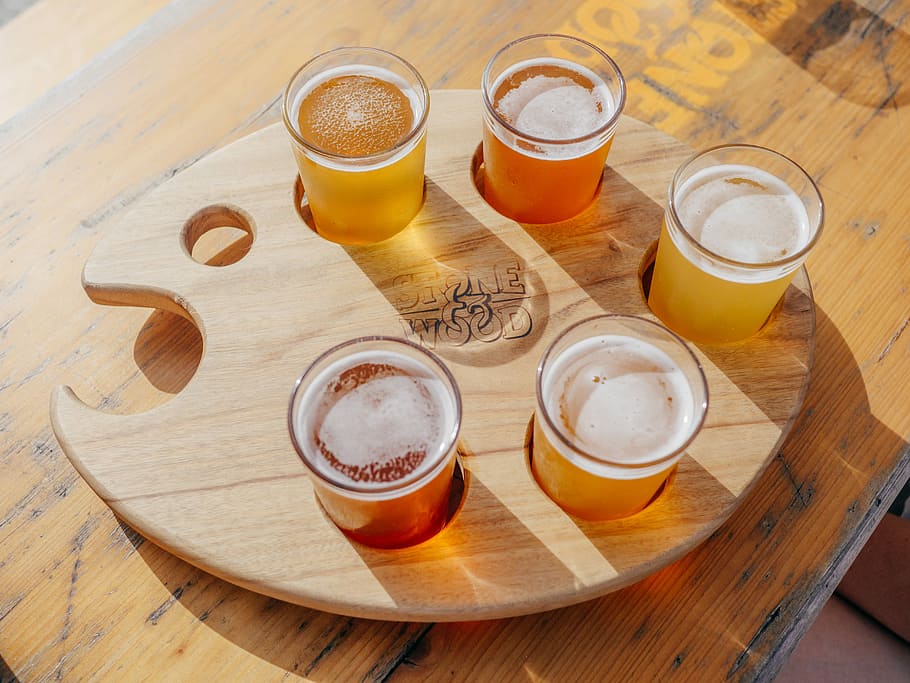 five poured drinking glasses on brown wooden tray, clear drinking glass on paint palette HD wallpaper