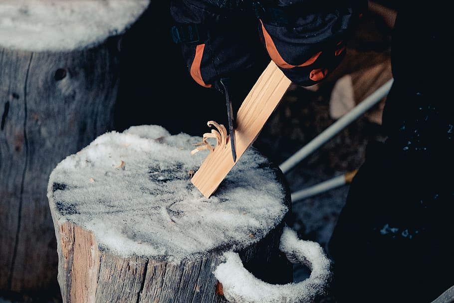 focus photography of person sharpening wood plank, person standing near tree log HD wallpaper