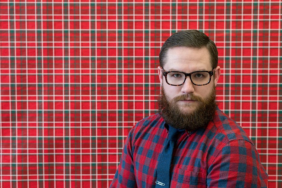 man wearing eyeglasses near red wall, man wearing red and blue gingham button-up shirt and black necktie HD wallpaper