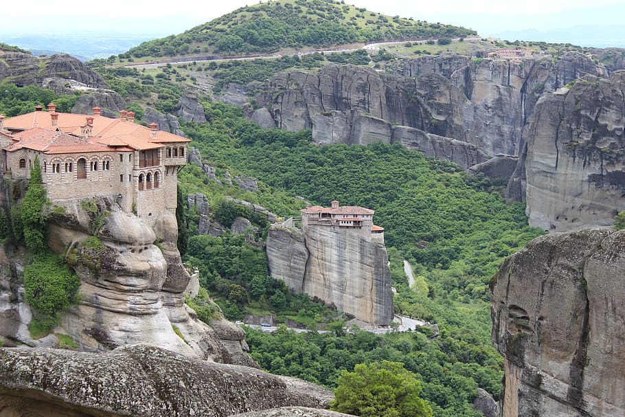 orange and beige concrete building on top of rock mountain during daytime HD wallpaper