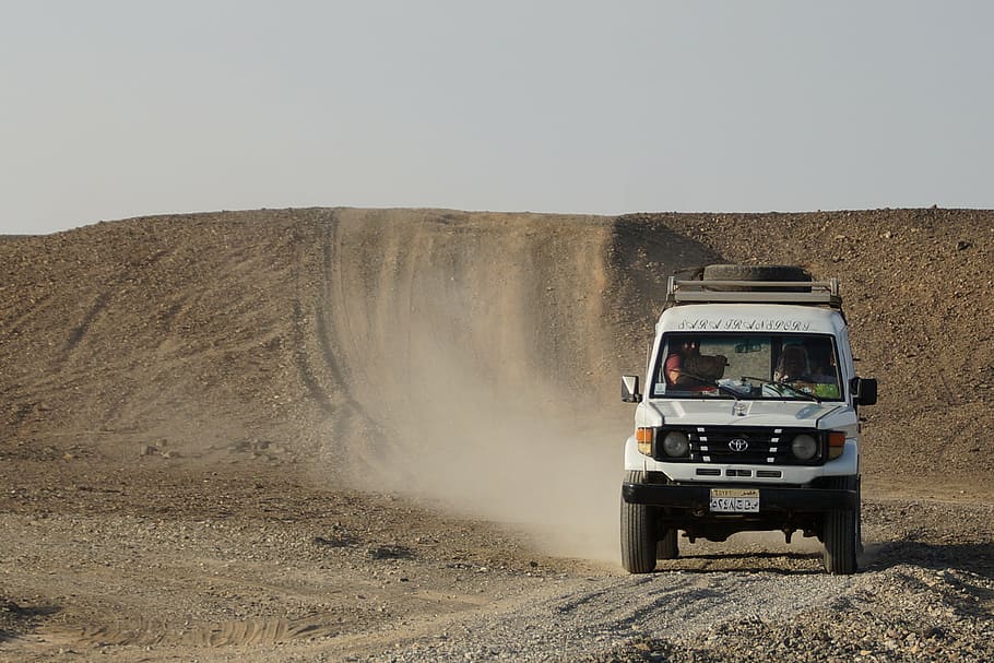 white SUV on dirt road at daytime, desert, sand, jeep, egypt