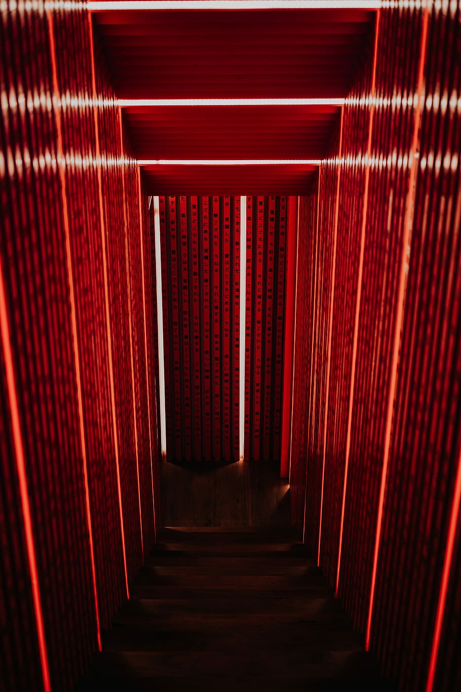 gray narrow stair with red wall, timelapse photography of red light
