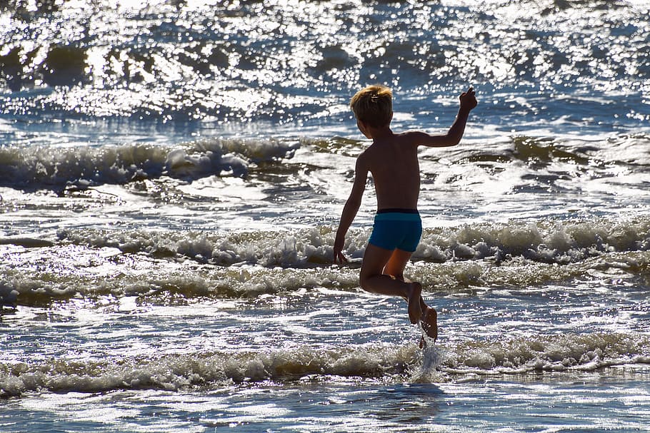 photo of boy walking on seashore, child, jump, wave, play, leisure activity HD wallpaper