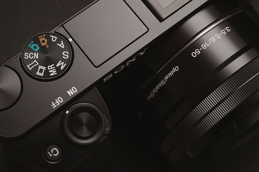 black DSLR camera, close view of black compact camera, electronic