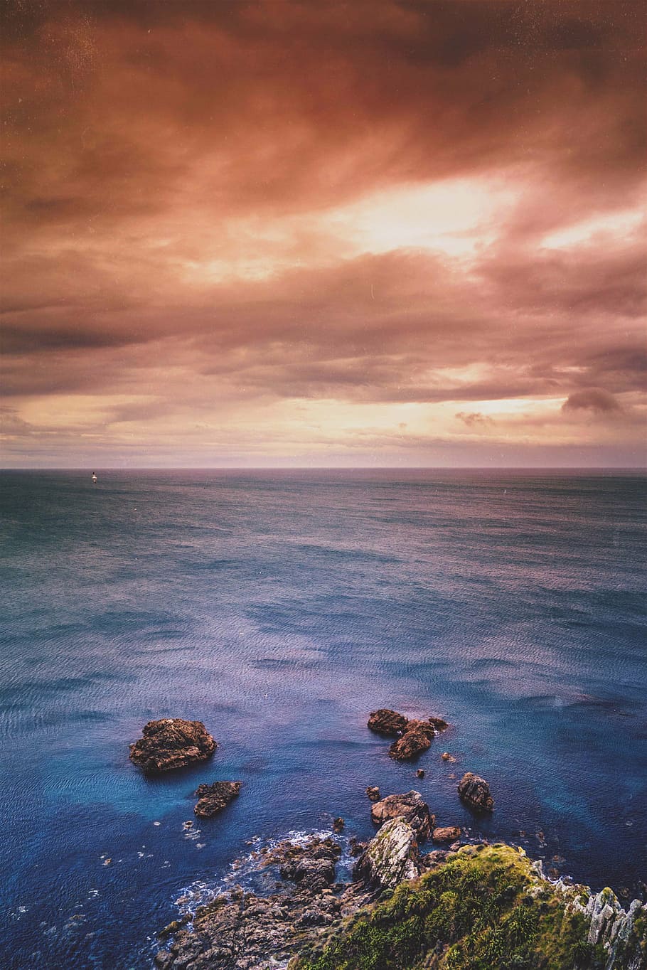 aerial view of rock formation on sea under gray sky during golden hour HD wallpaper