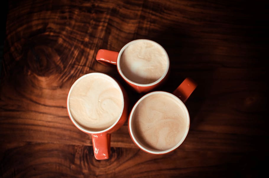 three red ceramic mugs with gray liquid inside, three red-and-and-white ceramic mugs HD wallpaper
