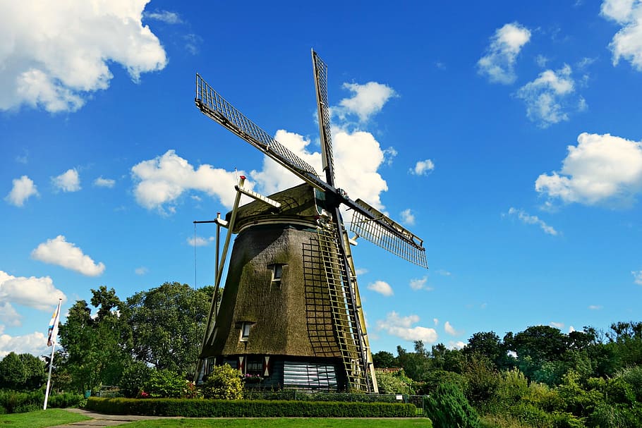 Brown and Black Windmill Under Cumulus Clouds Surrounded by Green Leaf Trees HD wallpaper