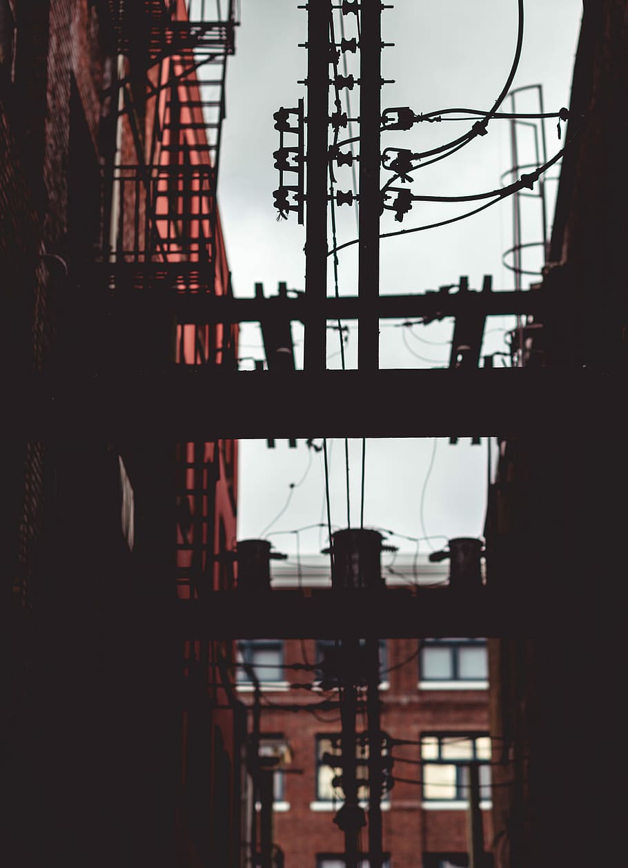 brown electric post near building at daytime, selective focus photography of utility post HD wallpaper