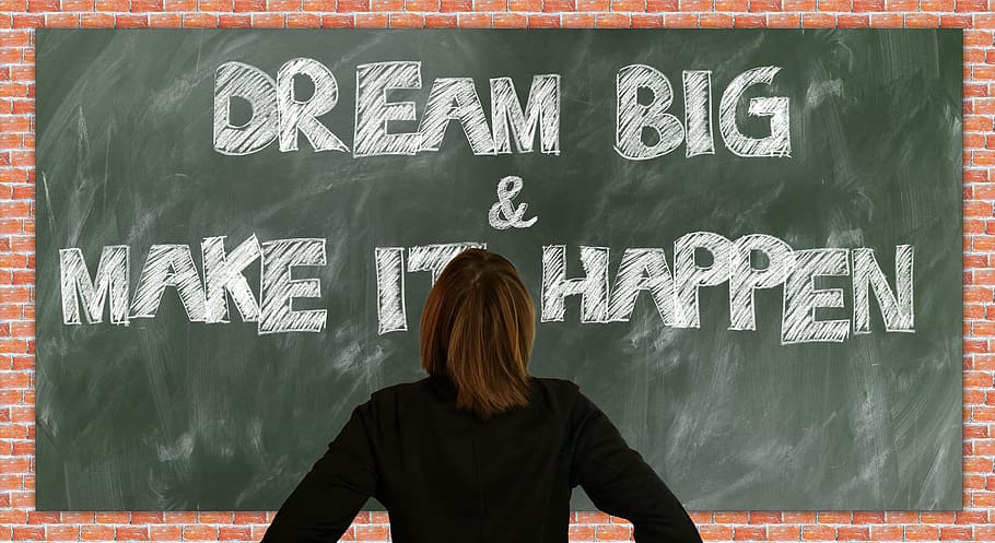 person in black long-sleeved shirt standing front of Dream Big & Make It Happen text, HD wallpaper