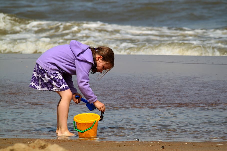 girl holding sand standing on the seashore, child, human, play