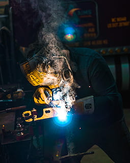 person welding metal tool, person wearing yellow welding mask HD wallpaper