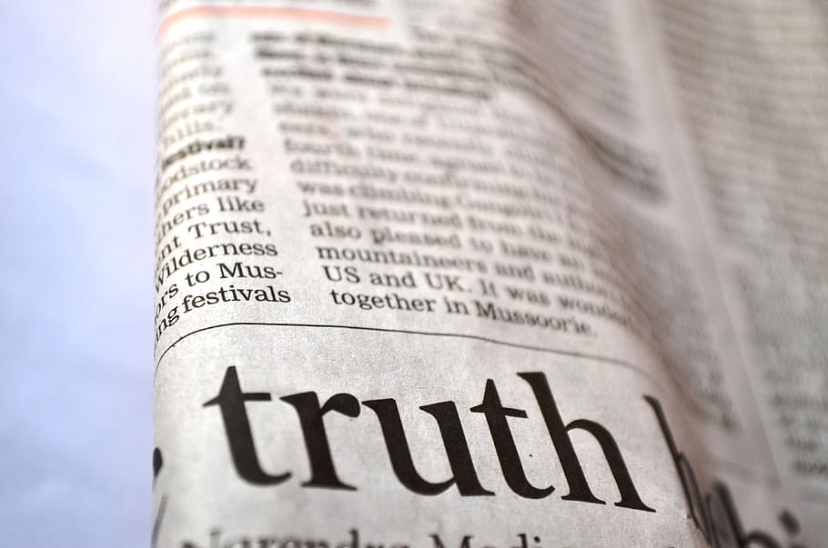 closeup photo of newspaper print showing Truth text, printed