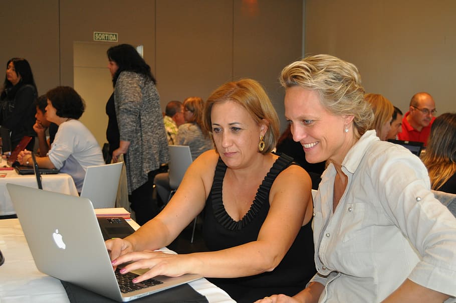 two woman using MacBook on white wooden table, nancy ballesteros HD wallpaper