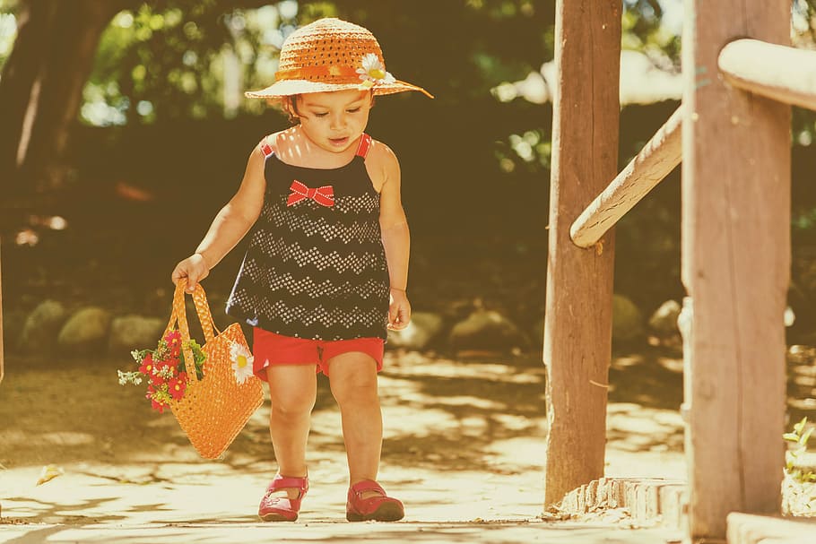 girl holding basket beside brown post, baby, walking, retro, child